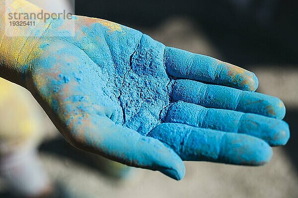Close up Person s Hand hält blau holi Farbe
