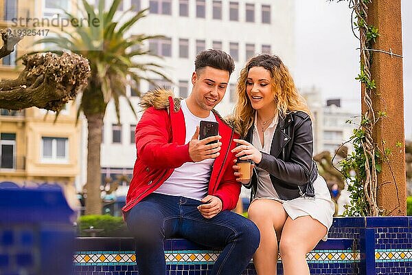 Lebensstil eines kaukasischen Paares  das Urlaubstourismus betreibt  in einem Stadtpark  das sich mit dem Handy Dinge im Internet ansieht