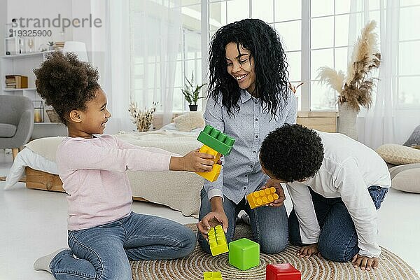 Vorderansicht glückliche Mutter  die zu Hause mit ihren Kindern spielt