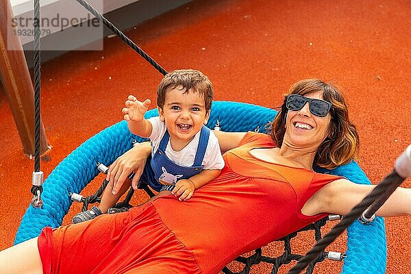 Baby spielt auf einem Spielplatz und hat Spaß im Sommer  mit seiner Mutter