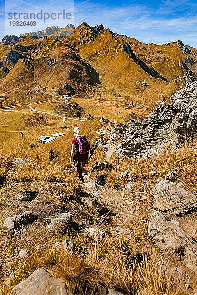 Wanders Frau auf Weg zum Gipfelkreuz in felsiger Gebiergslandschaft im Herbst  Hirschkarspitze  Alpen  Österreich  Europa