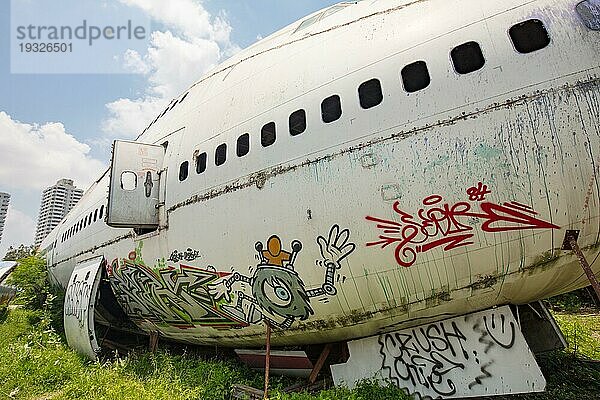 Überreste einer zerstörten und mit Graffiti beschmierten Boeing 747 und zwei McDonnell Douglas MD 80 auf einem Feld in Bangkok  Thailand  die nie wieder geflogen werden sollten. Jetzt Heimat einer Familie  Asien