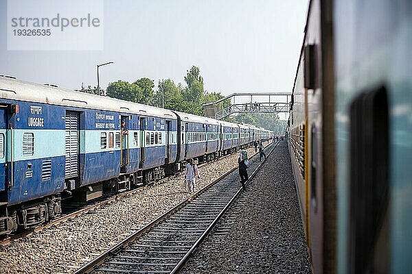 Jodhpur  Indien  10. Dezember 2019: Menschen auf den Bahngleisen zwischen zwei geparkten Zügen am Bahnhof von Jpdphur  Asien