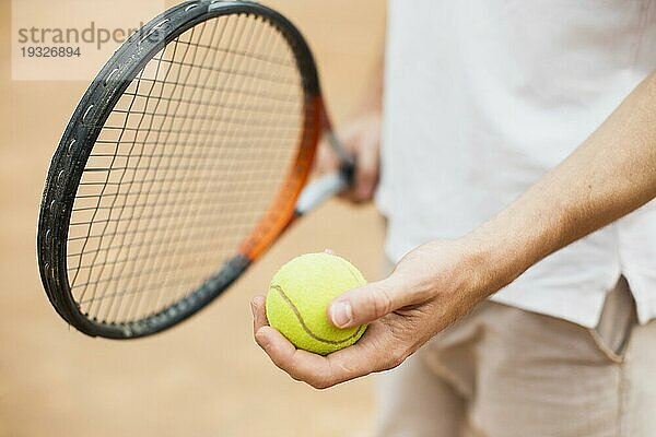 Mann hält Tennisballschläger