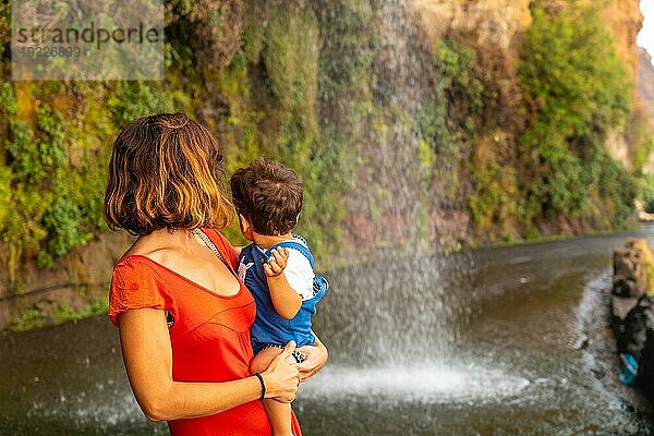 Eine Mutter mit ihrem Sohn im Urlaub am Anjos Wasserfall  Madeira  hat Spaß