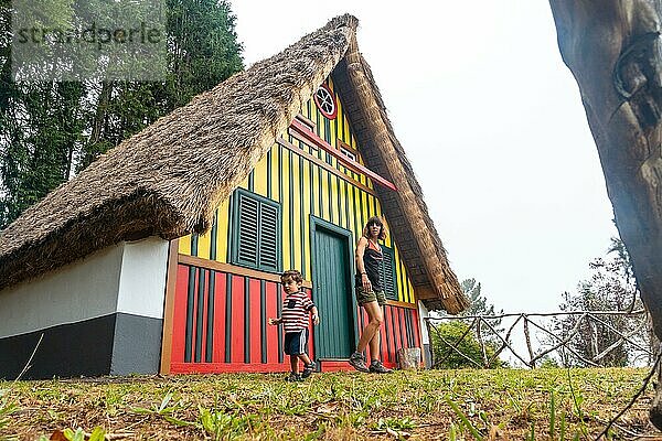 Mutter und Sohn spielen in einem traditionellen madeirensischen Haus wie dem in Santana im Wald von Caldeirao Verde  Santana