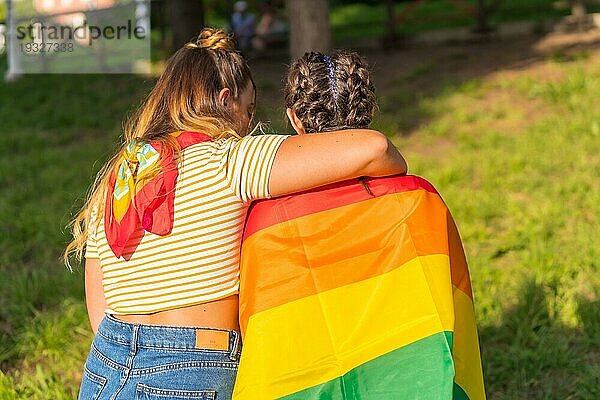 Eine Nahaufnahme von zwei jungen kaukasischen Frauen halten LGBT Stolz Flagge im Freien