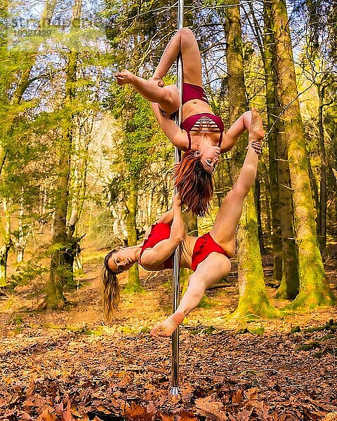 Zwei kaukasische Akrobaten tanzen Stangentanz im Wald im Herbst