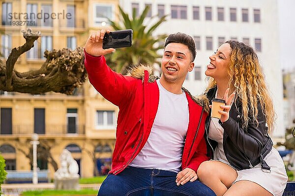 Lifestyle eines kaukasischen Paares beim Sightseeing im Urlaub  in einem Stadtpark  das lächelt und ein Foto mit dem Telefon macht