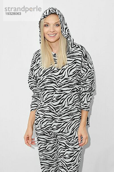 Schöne Frau in gemustertem Zebra Fleece Anzug mit Kapuze