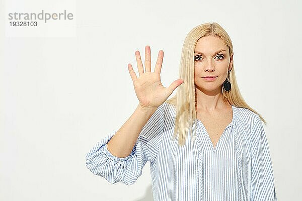 Attraktive blonde Frau zeigt fünf Finger. Zählen mit Fingern