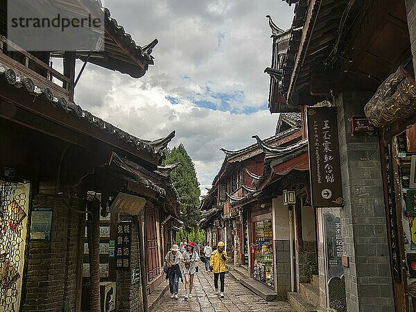 Gassen mit alten chinesischen Holzhäusern und bummelnden Passanten  historische Altstadt von Lijiang  Yunnan  China  Asien