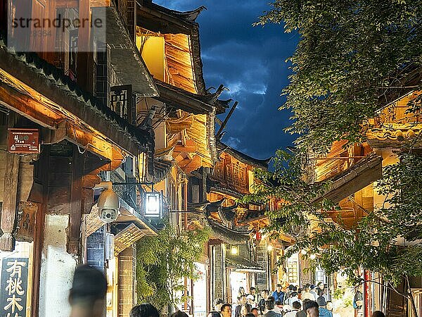 Alte beleuchtete chinesische Holzhäuser  viele Menschen in den Gassen  historischen Altstadt von Lijiang  Yunnan  China  Asien