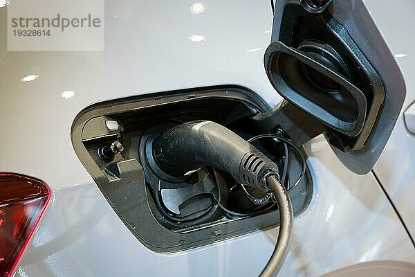 Charging Port Buchse Stecker in modernen Elektrofahrzeug EV Auto Nahaufnahme mit Ladekabel. Umwelt Ökologie alternative grün erneuerbare saubere nachhaltige Energie Null Emissions Konzept