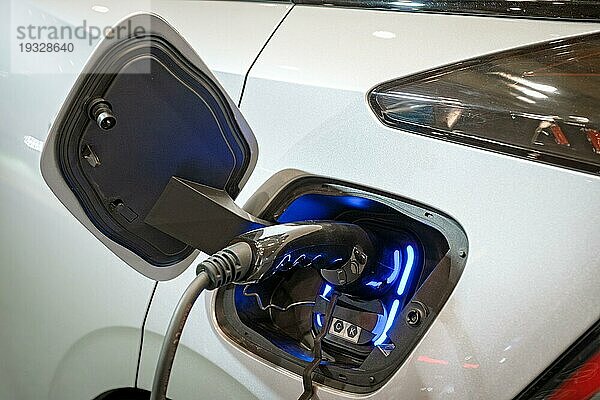Charging Port Buchse Stecker in modernen Elektrofahrzeug EV Auto Nahaufnahme mit Ladekabel. Umwelt Ökologie alternative grün erneuerbare saubere nachhaltige Energie Null Emissions Konzept