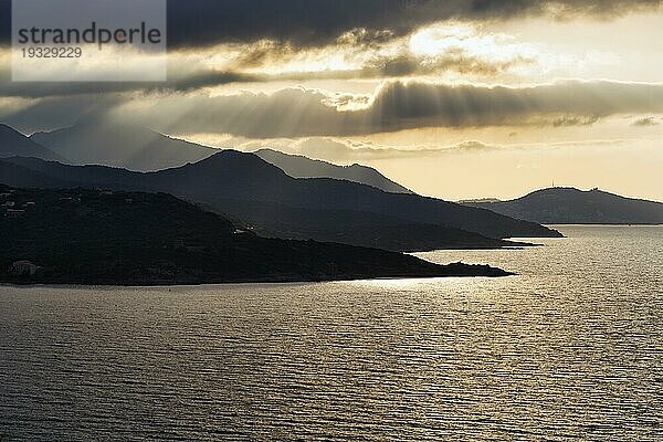 Küstenlinie im Gegenlicht  Sonnenstrahlen durch Wolken  L'Île-Rousse  Ile Rousse  Haute-Corse  Balagne  Nordküste  Korsika  Frankreich  Europa