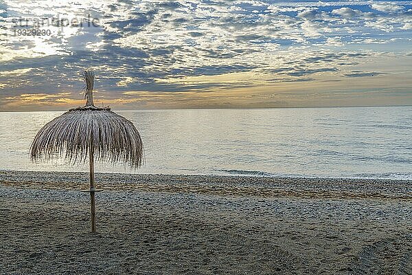 San Pedro Alcantara  Málaga  Spanien Meereslandschaft mit strohgedeckten Sonnenschirmen in der Morgendämmerung und ruhiger See