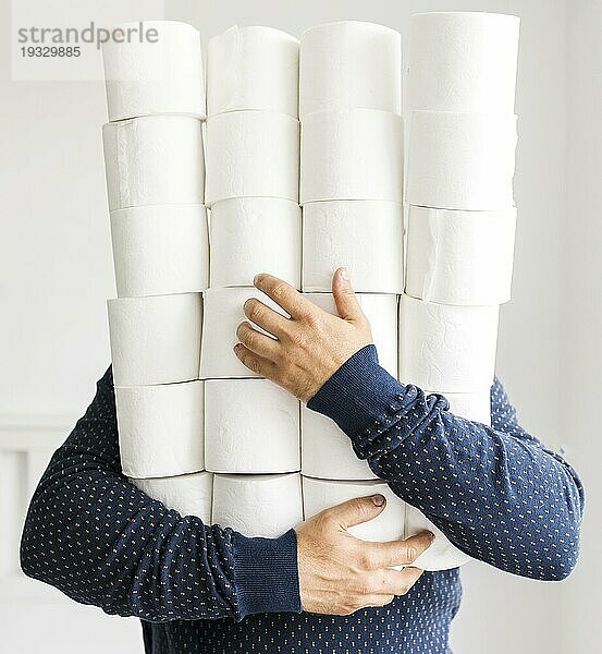 Mann mit Stapel Toilettenpapier