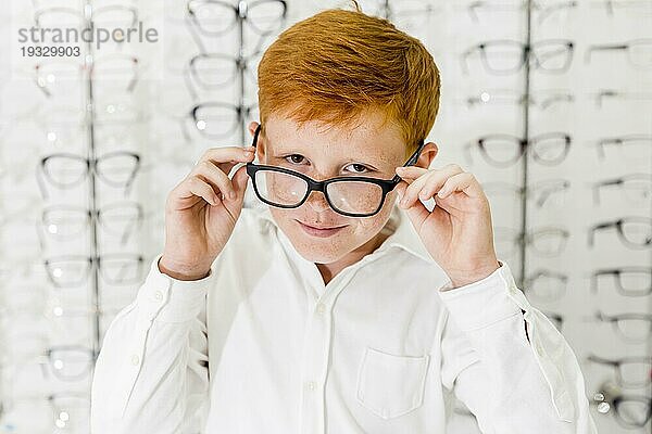 Lächelnder Junge mit Sommersprosse sein Gesicht trägt Brille suchen Kamera