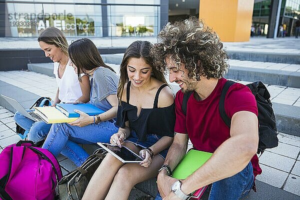 Schüler benutzen Tablet in der Nähe von Freunden