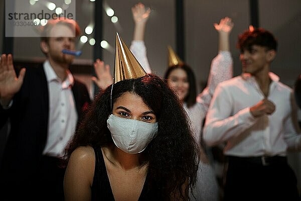 Frau trägt medizinische Maske ihre Freunde Silvesterparty