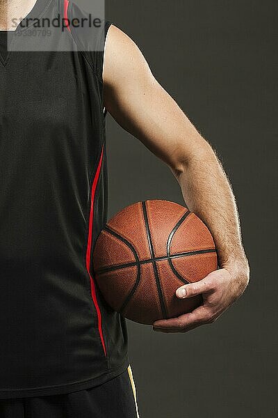 Vorderansicht eines vom Spieler gehaltenen Basketballs nahe am Körper