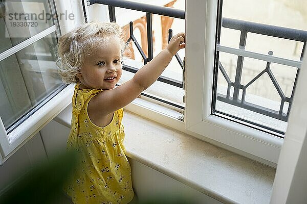 Kind schaut während der Quarantäne durch das Fenster