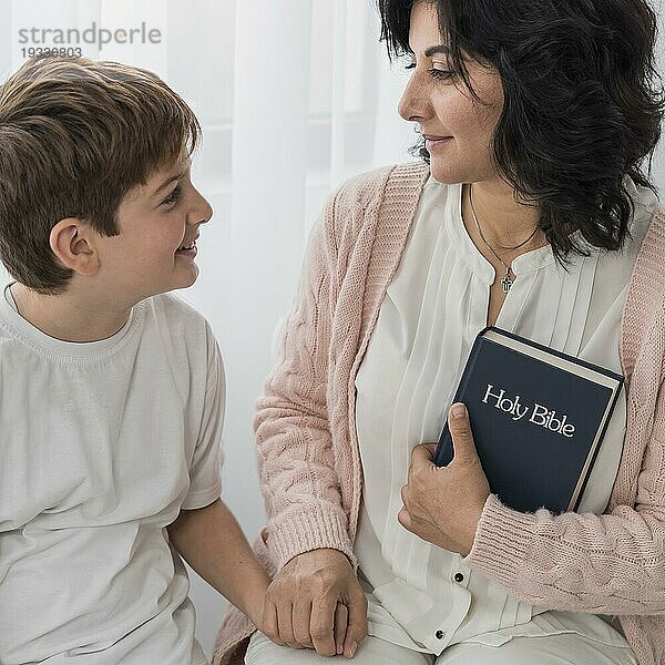 Frau hält Bibel mit ihrem Kind