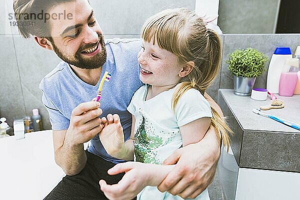 Fröhlicher Vater Tochter beim Zähneputzen