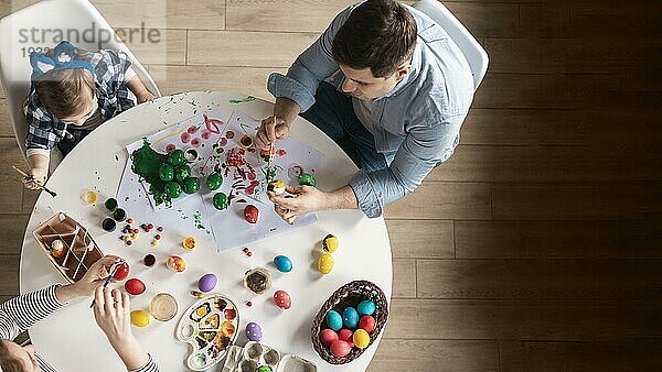 Draufsicht Familie malt traditionelle Ostereier