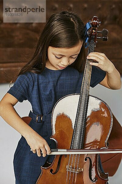 Kleines süßes Mädchen lernt Cello spielen