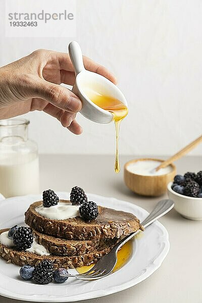 Vorderansicht von Hand gegossener Honigtoast mit Blaubeeren