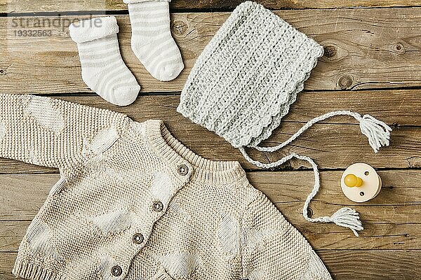Overhead Ansicht Wolle Baby s Kleidung mit Schnuller Holztisch