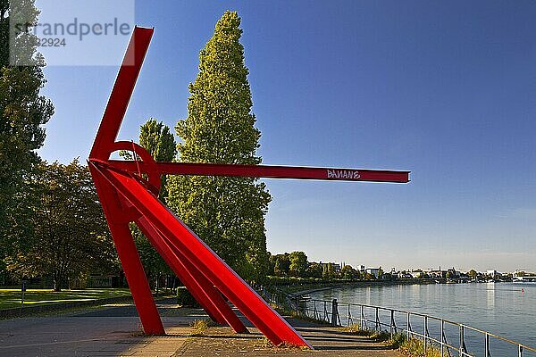 Knallrote Skulptur aus Stahlprofilen L'Allumé von Mark di Suvero  Rheinufer  zeigt Richtung Berlin  Bonn  Nordrhein-Westfalen  Deutschland  Europa
