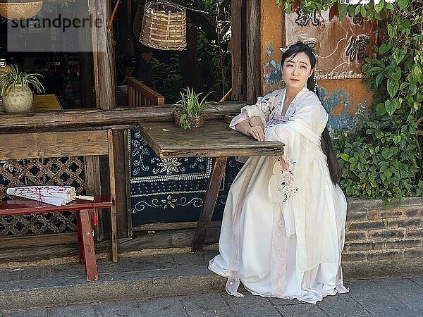 Frau in chinesischer Nostalgie mit altem luxuriösen weißen Kleid vor altem Haus  historische Altstadt Dali  Yunnan  Chin