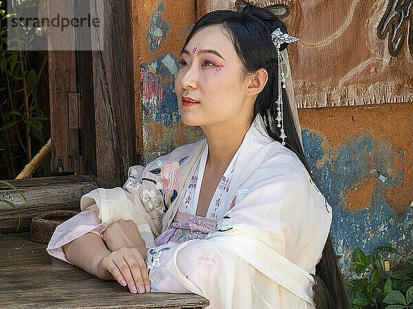 Frau in chinesischer Nostalgie mit altem luxuriösen weißen Kleid vor altem Haus  historische Altstadt Dali  Yunnan  Chin