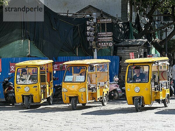 Straße mit gelben Rikschas und Taxis  Dali  Yunnan  China  Asien