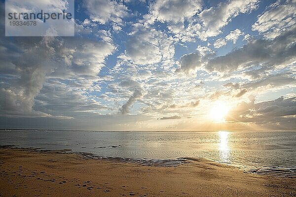 Sonnenaufgang am Sandstrand. Landschaftsaufnahme mit Blick auf das Meer und den Strand. Lichtwellen und eine Morgenatmosphäre  die es nur in Sanur  Bali  Indonesien gibt