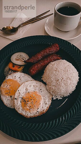 Vertikale Draufsicht auf Spiegeleier  Longganisa und Reis  gepaart mit schwarzem Kaffee  typisches tägliches philippinisches Frühstücksessen