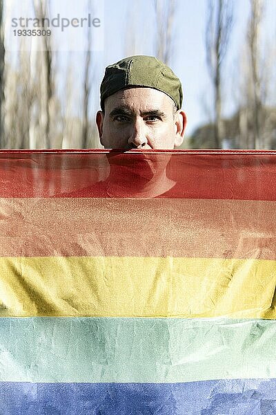 Schwuler Mann hält LGBTregenbogenflagge