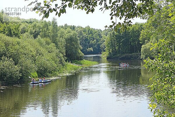 Eine Gruppe von Menschen fährt mit Kajaks einen schönen Fluss entlang. Sommerferien. Sport und Erholung auf dem Fluss im Sommer. Kajakfahren auf dem Fluss. Freunde verbringen Zeit zusammen Segeln im Fluss