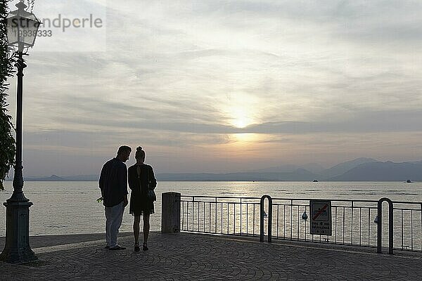 Seeufer bei Sonnenuntergang  Silhouette eines Pärchens  Torri del Benaco  Gardasee Ostufer  Provinz Verona  Italien  Europa