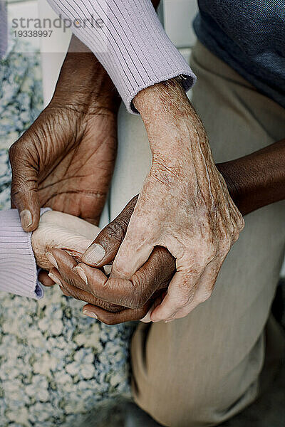 Mittelteil eines älteren Mannes und einer älteren Frau  die sich an den Händen halten