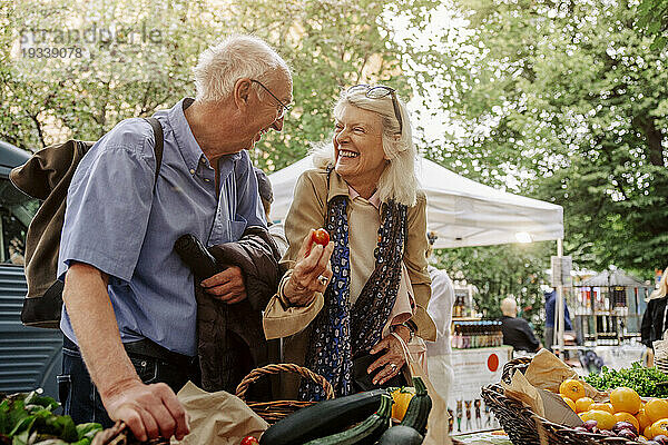 Fröhliche ältere Frau und Mann genießen den Markt
