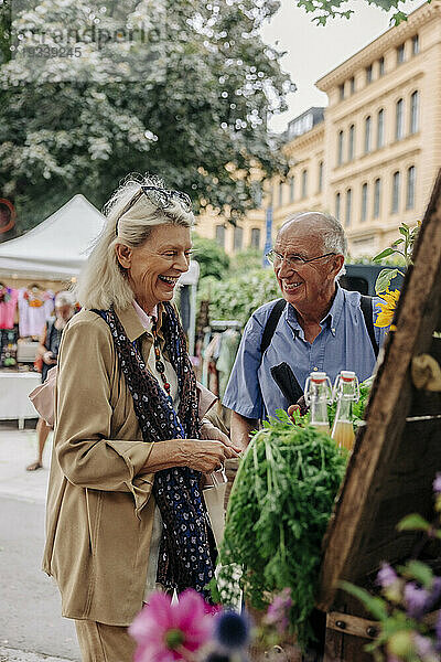 Glückliches älteres Paar auf dem Bauernmarkt in der Stadt