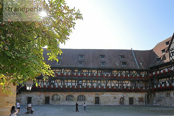 Innenhof vom Alte Hofhaltung erbaut 15. Jhdt mit Blumendekoration im Gegenlicht  Touristen  Fachwerkhaus  Palais  Holzkonstruktion  Bamberg  Oberfranken  Franken  Bayern  Deutschland  Europa