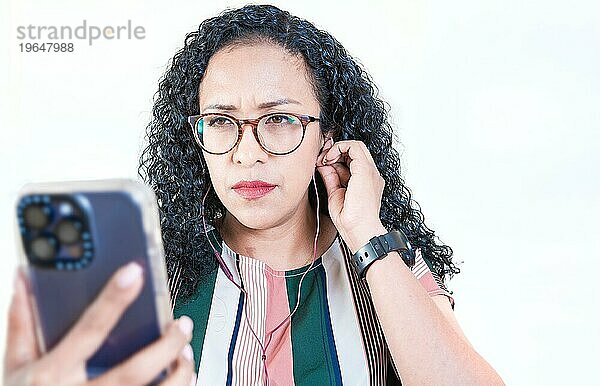 Junge Afro Frau hört Musik mit Kopfhörern isoliert. Close up von afro Mädchen hören Songs mit Handy auf isolierten Hintergrund