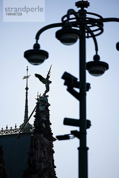 Engelsfigur mit Schwert auf dem Dach vom Rathaus kämpft gegen einen Mast mit Lampen und Videokameras  Überwachungskameras  Rathausmarkt  Hamburg  Deutschland  Europa