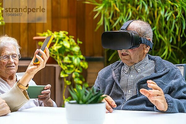 Virtual Reality Erlebnis für ältere Menschen in einem geriatrischen Sitz im Garten