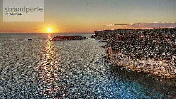 Sonnenuntergang  Sonnenstrahl auf dem Meer  Gegenlicht  Wolken  Steilküste  Isola dei Conigli  Spiaggia dei Conigli  Riserva Naturale Orientata Isola di Lampedusa  Insel Lampedusa  Provinz Agrigento  Pelagische Inseln  Sizilien  Italien  Europa